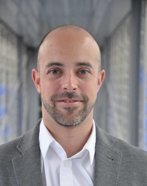 Jordi-Joan Giménez smiling, in a grey blazer and white shirt